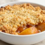 Délicieux crumble aux nectarines préparé dans un Airfryer avec une croûte dorée et croustillante.