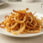 Délicieux oignons frits cuit à la perfection dans l'Airfryer, croustillants et savoureux.